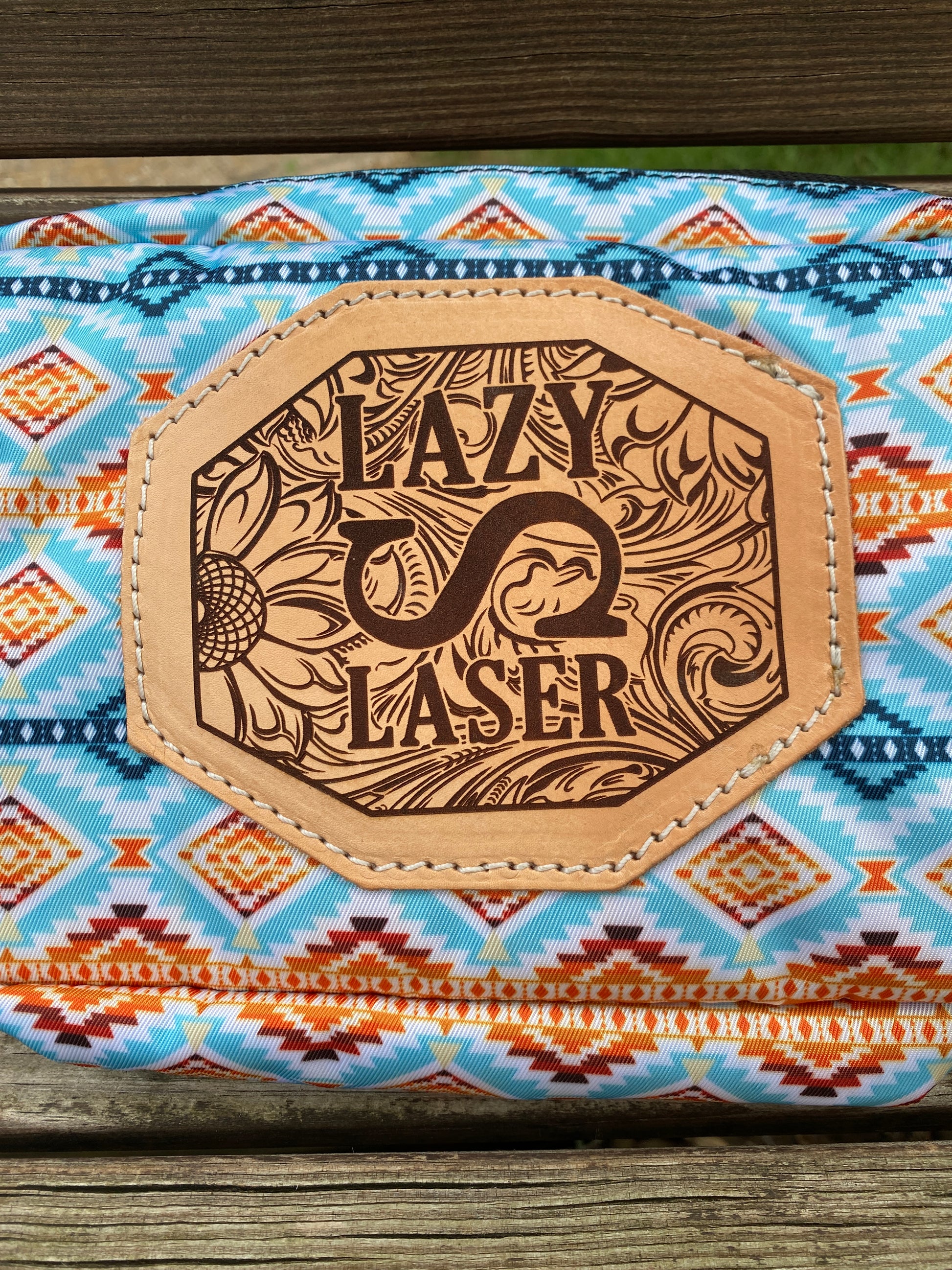 Decorative leather patch with 'Lazy S' branding on a patterned fabric background