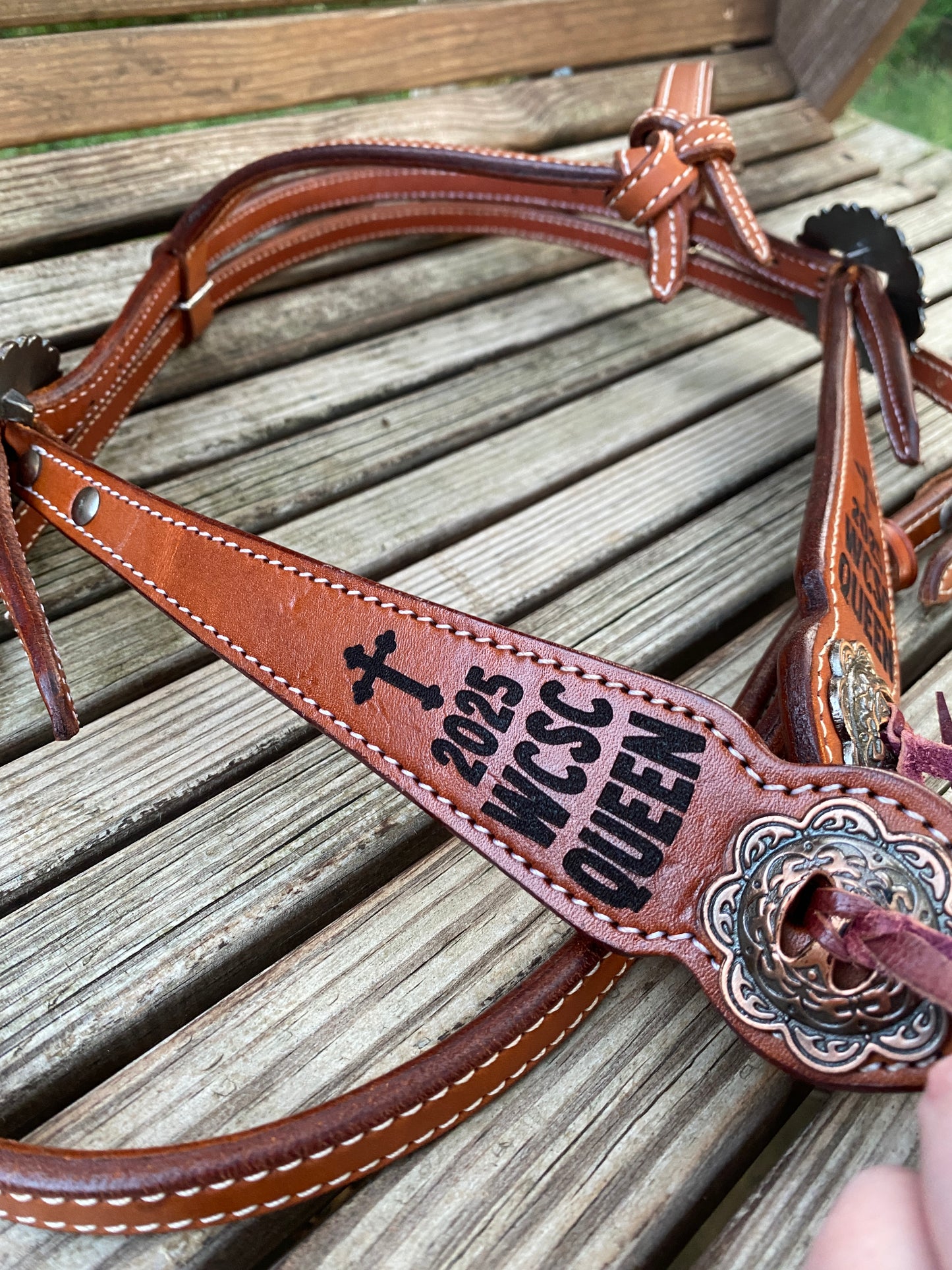 chestnut leather bridle with engraved award text and a cross detail