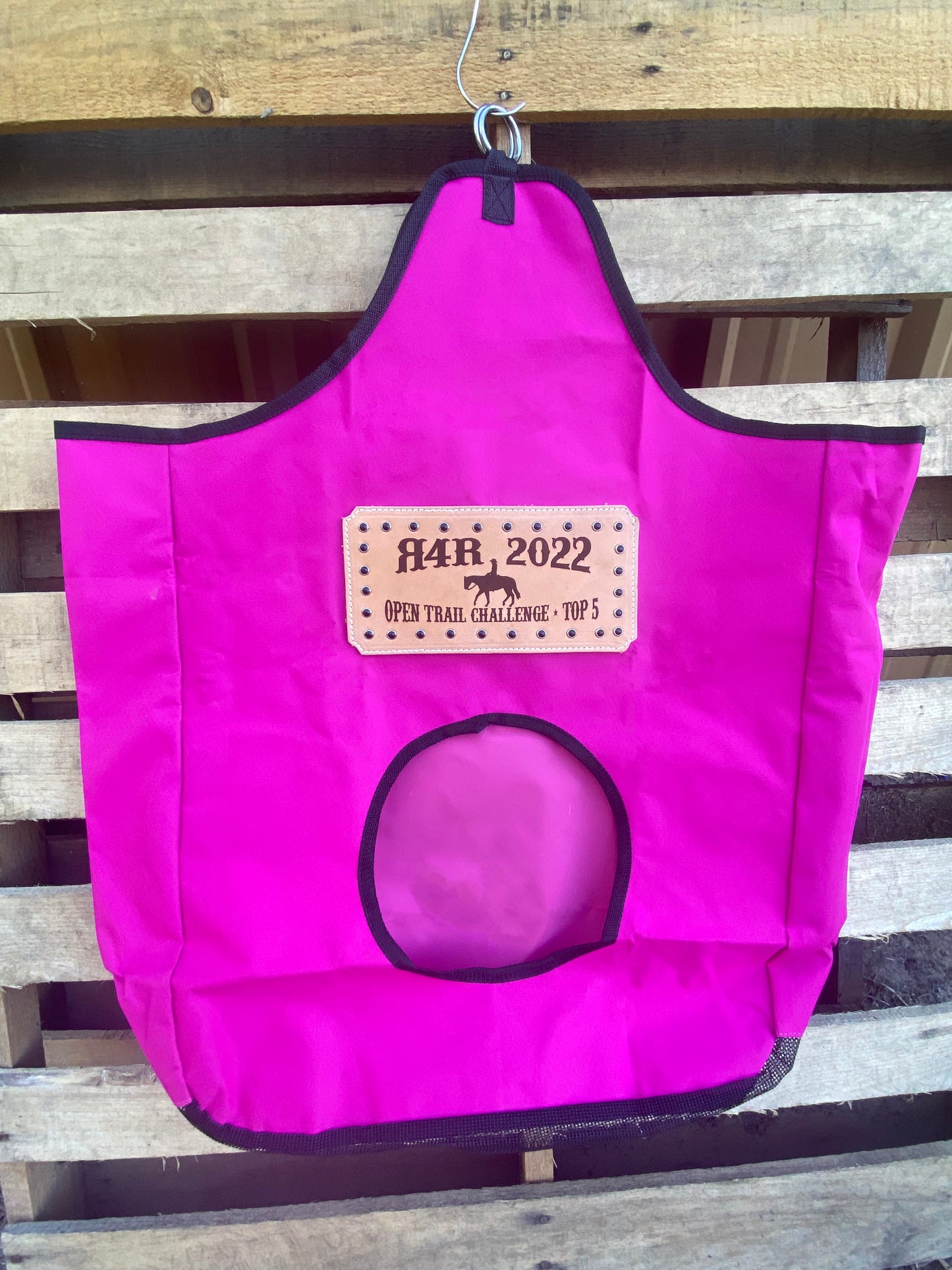 pink award hay bag with a leather patch displaying a western horse rider art and decorative crystals around the edges