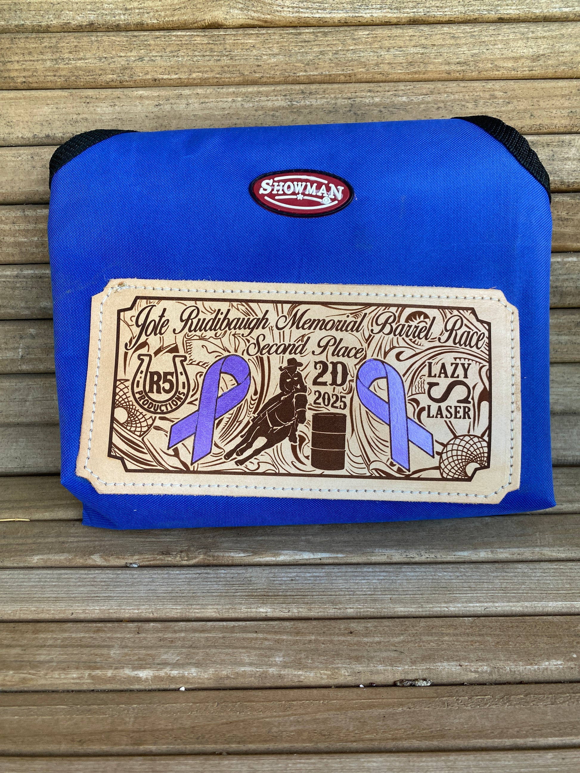 Blue durable nylon horse hay bag with a closeup view of a laser engraved custom leather patch