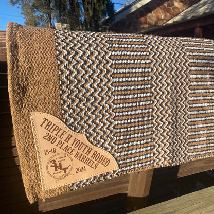 tan zigzag saddle blanket double weave displayed outdoors highlighting engraved leather corner