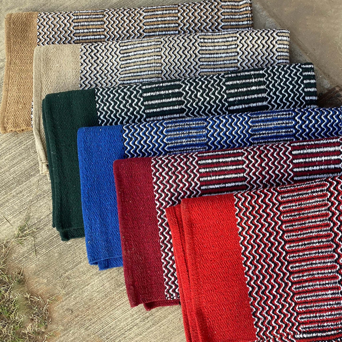 Color choices for navajo pattern saddle blankets color displayed neatly on a concrete backdrop.